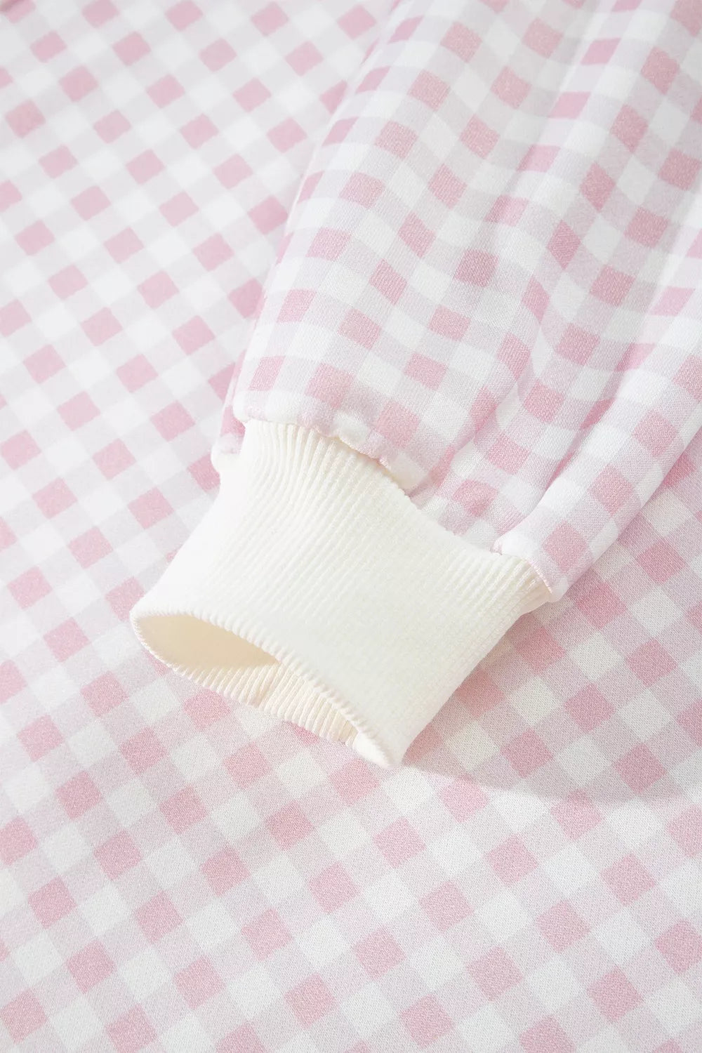 Close-up of the gingham sweatshirt sleeve with a ribbed cuff