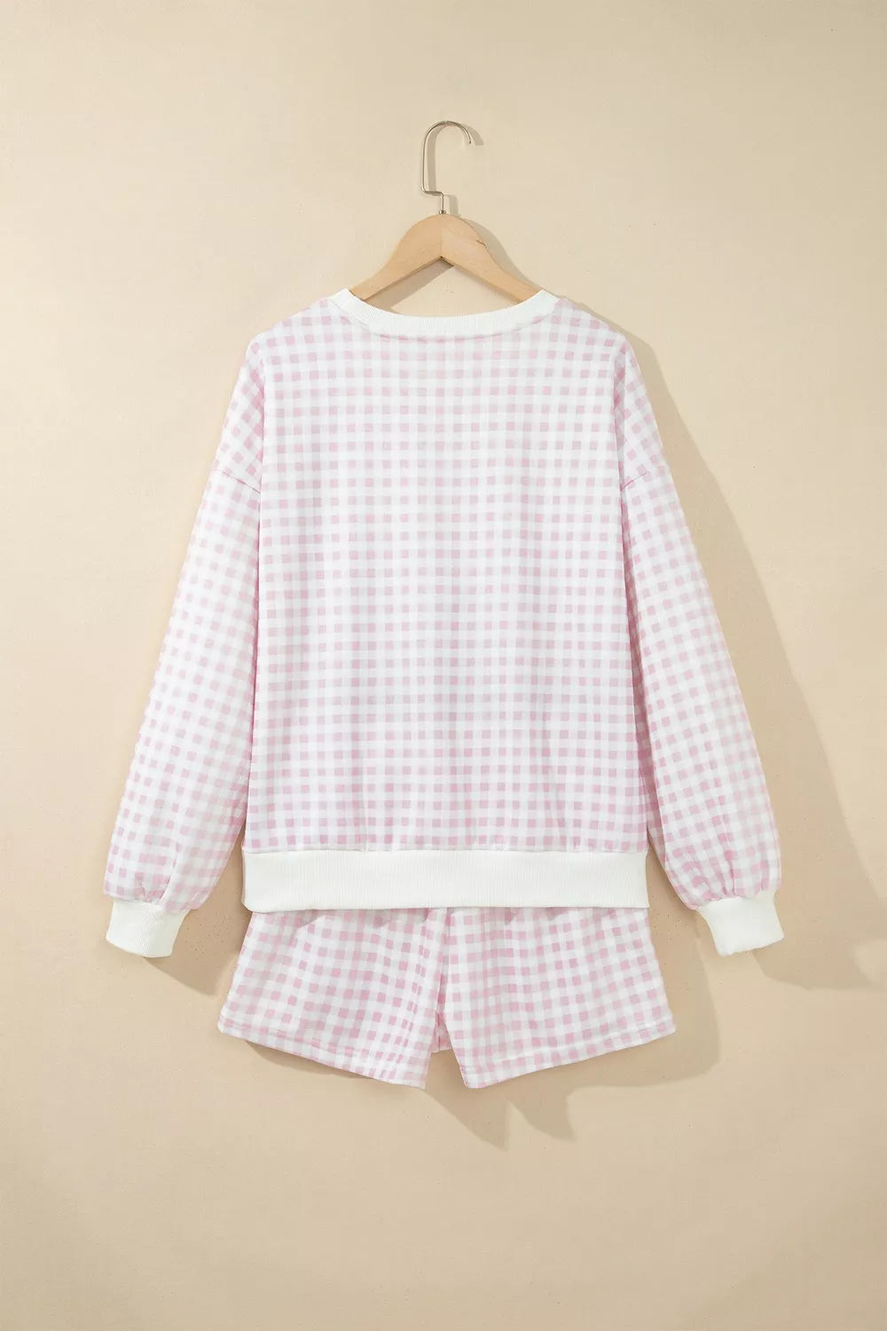 Back view of the gingham sweatshirt and shorts displayed on a hanger