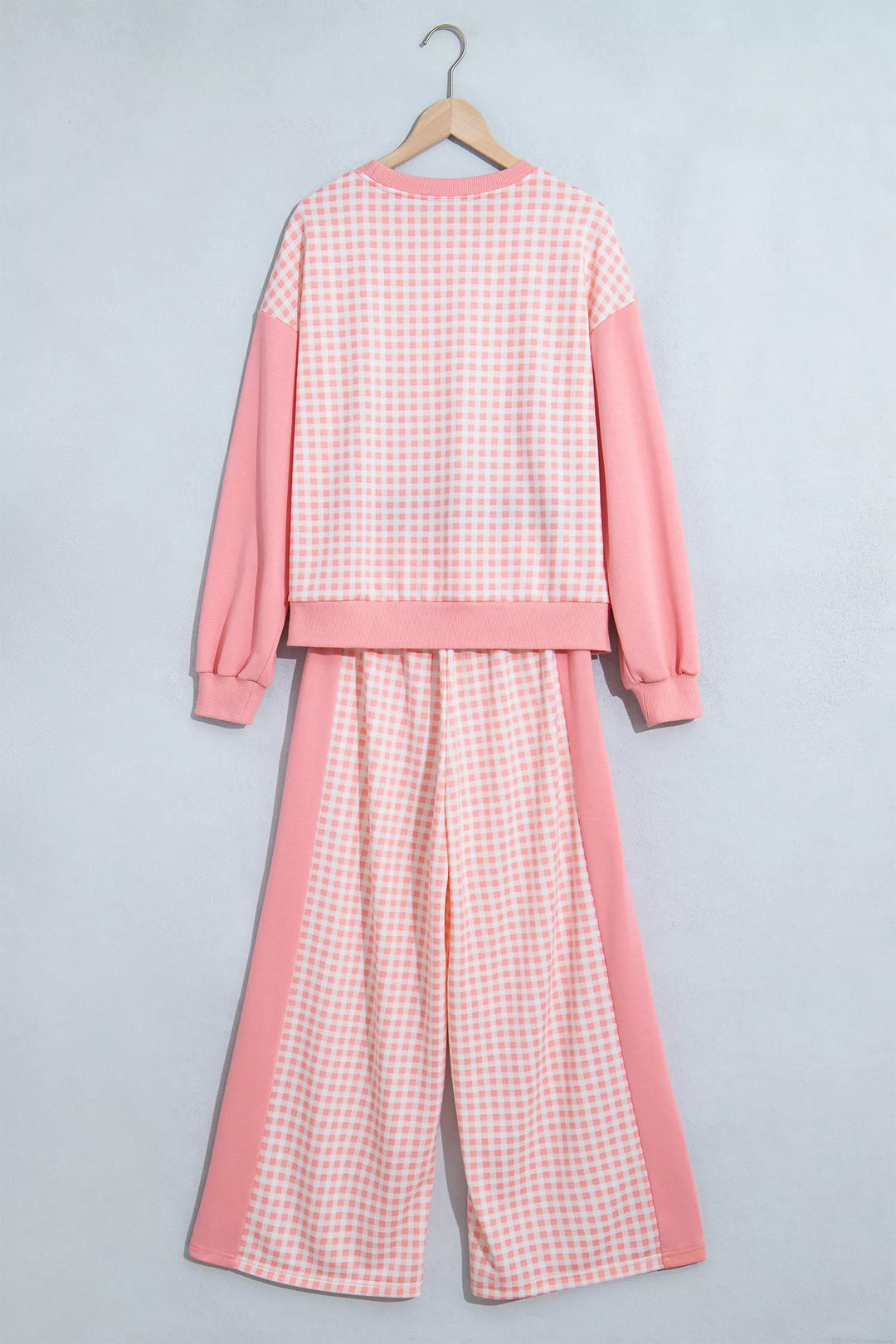 Back of the coral pink gingham sweatshirt and wide leg pants on a hanger