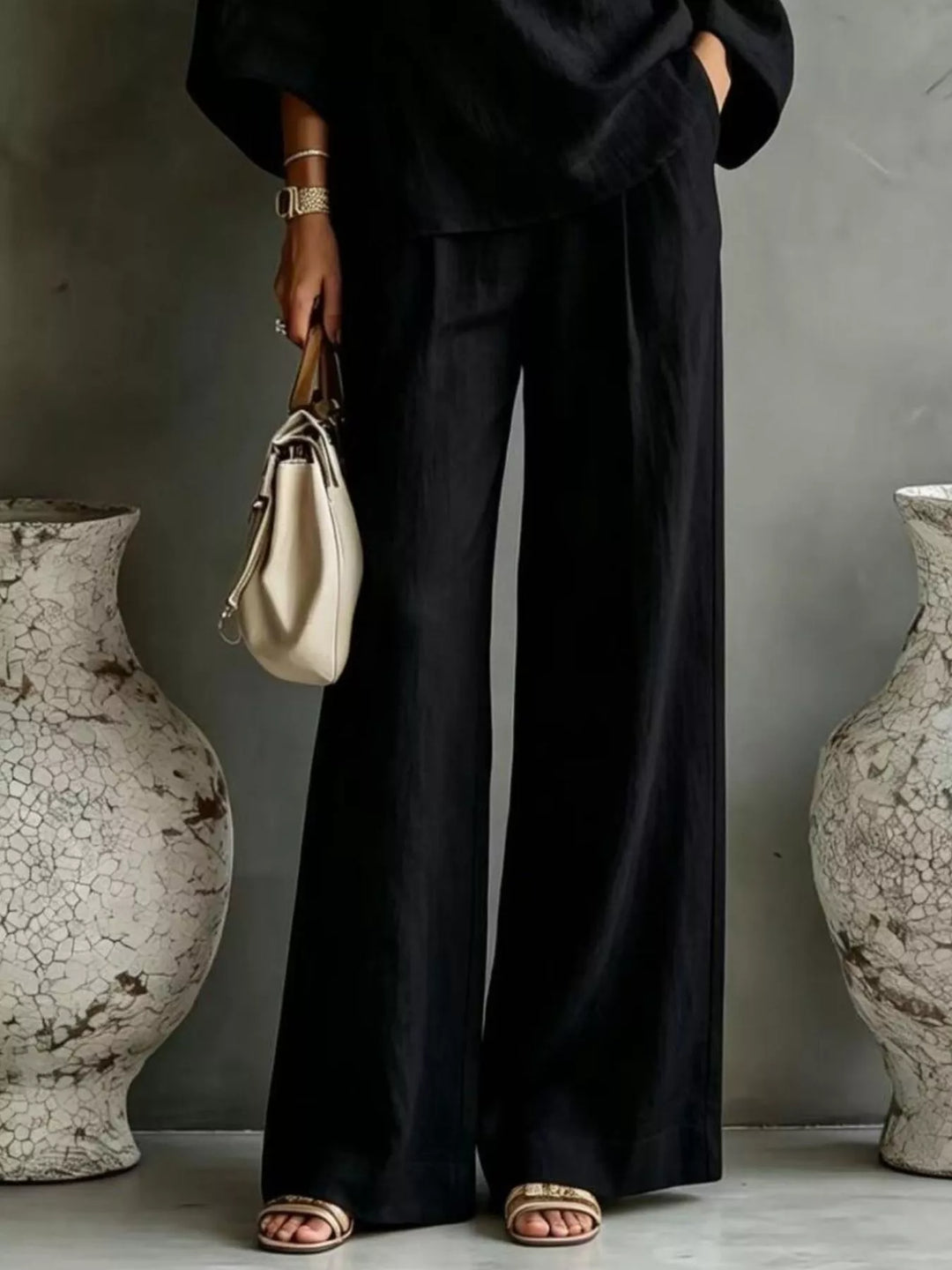 Black wide leg pants and top set worn with a cream handbag