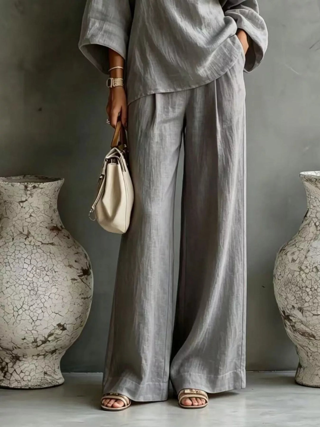 Gray wide leg pants and top set worn with a cream handbag