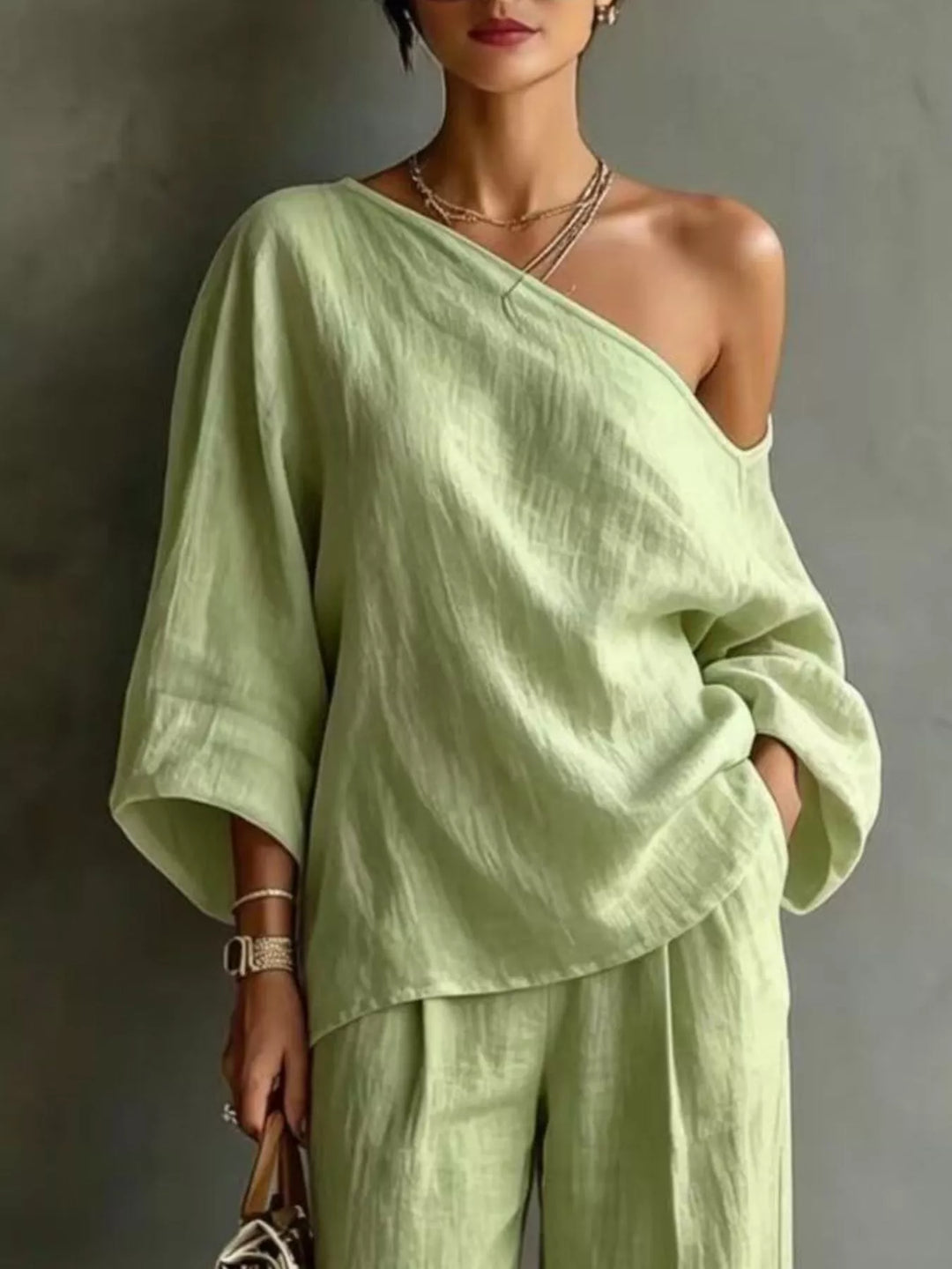 Close-up of the pistachio green one shoulder top with batwing sleeves