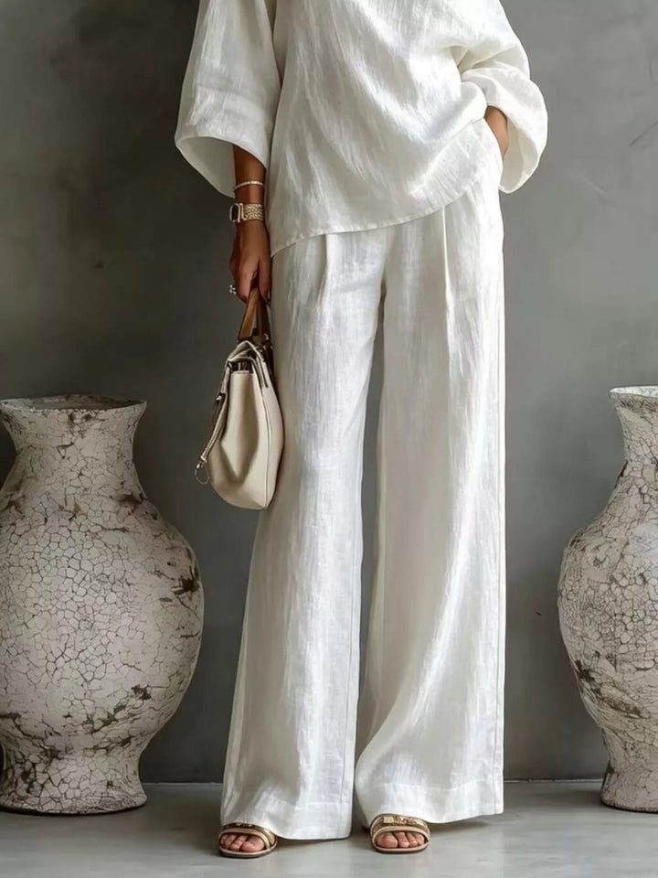 White wide leg pants and top set worn with a cream handbag