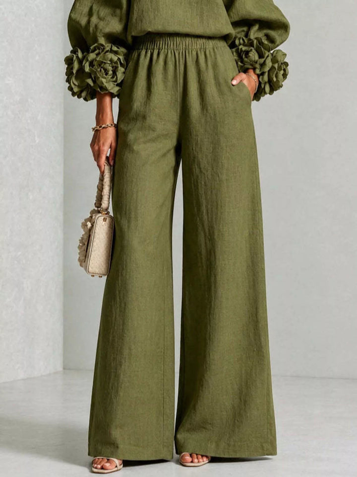 Detail of the moss wide leg pants with pockets and a small handbag