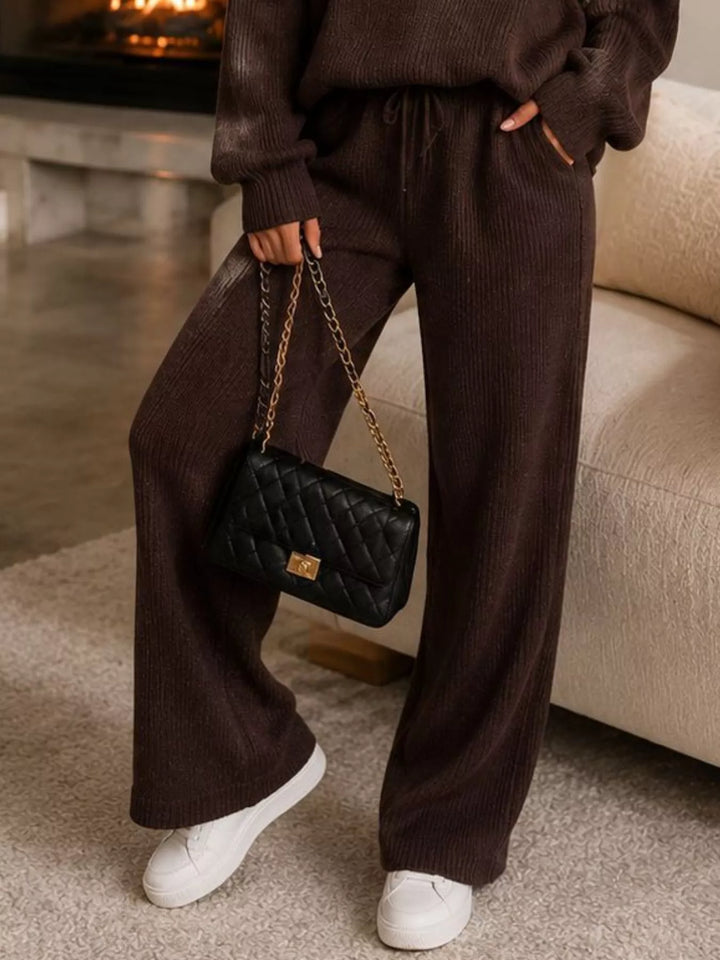 Detail of the chocolate wide leg pants with white sneakers and a chain bag