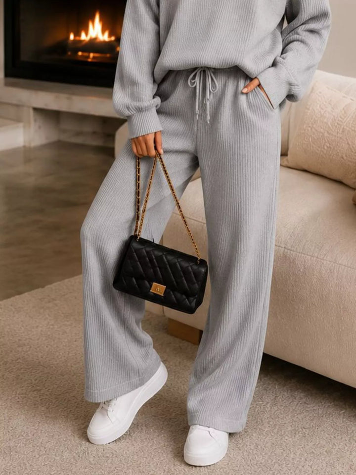 Detail of the light gray ribbed wide leg pants with white sneakers