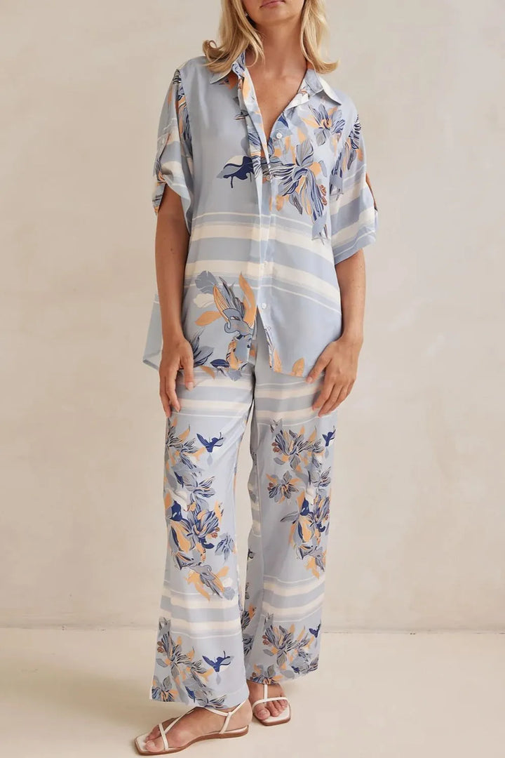 Full outfit in light blue floral showing the button up shirt and wide pants