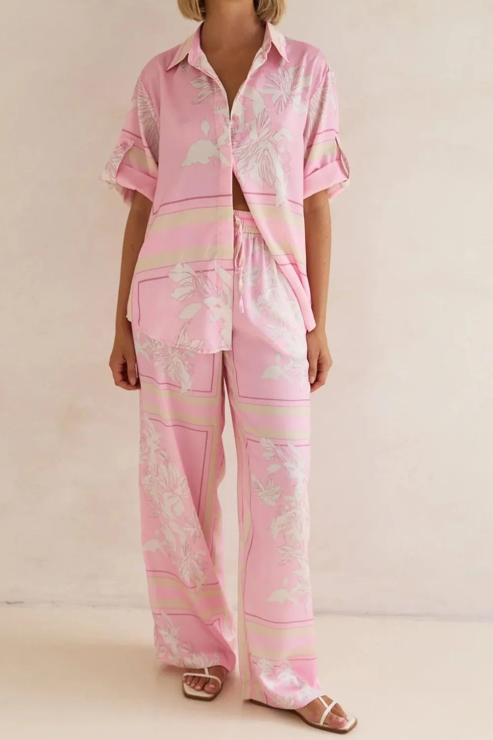 Pink floral set standing full length with wide leg pants and sandals