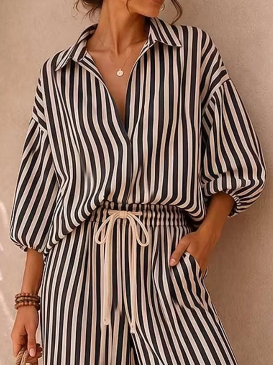 Close-up of the black striped shirt with drawstring waist of the pants