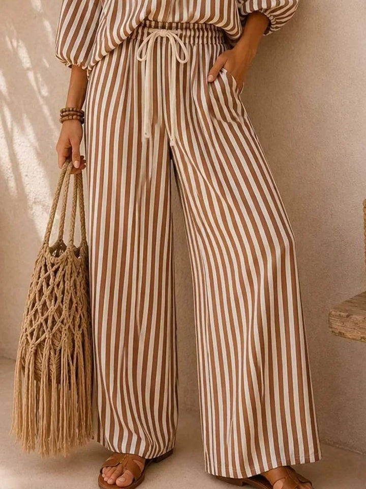 Brown striped wide leg pants with drawstring waist and a woven bag