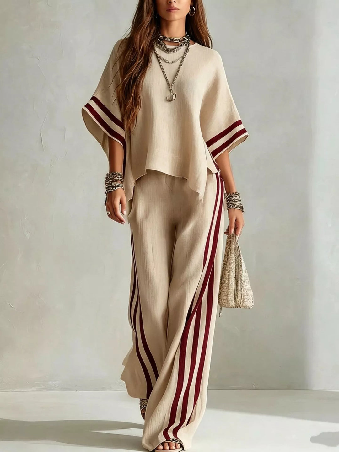 Women's matching set in beige, wide sleeve top with striped pants and a woven bag