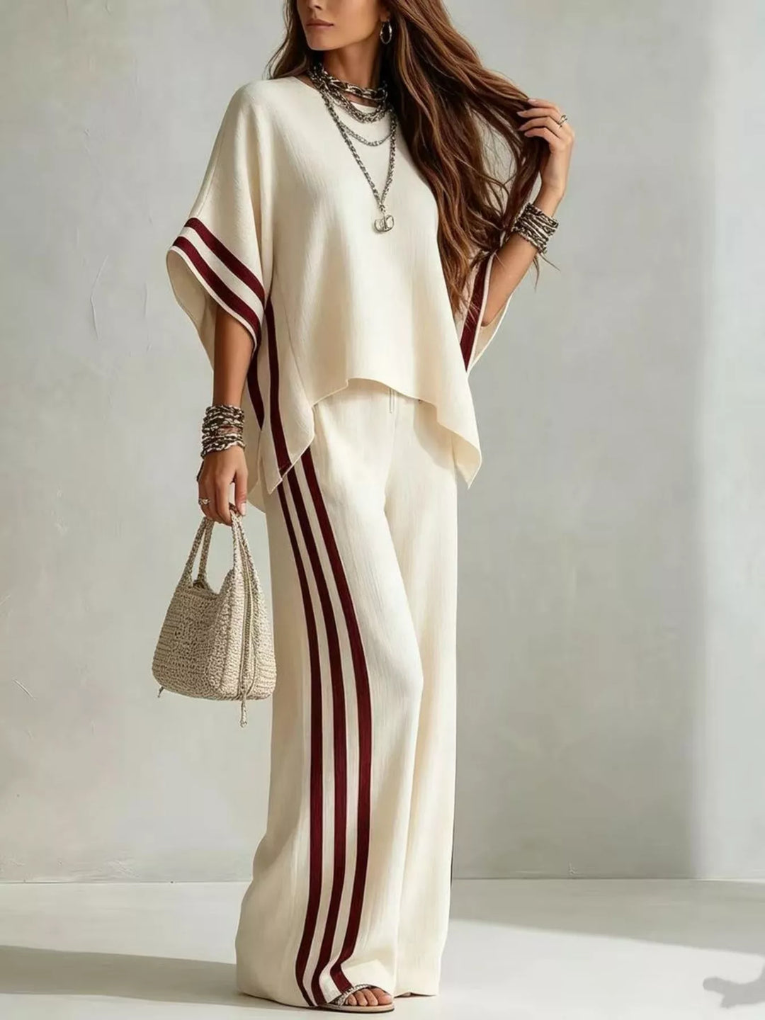 Cream striped pants set in a side angle, holding a small handbag