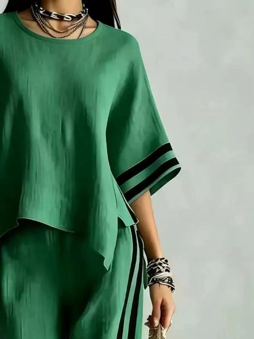 Close-up of the green wide sleeve top with black striped sleeve trim