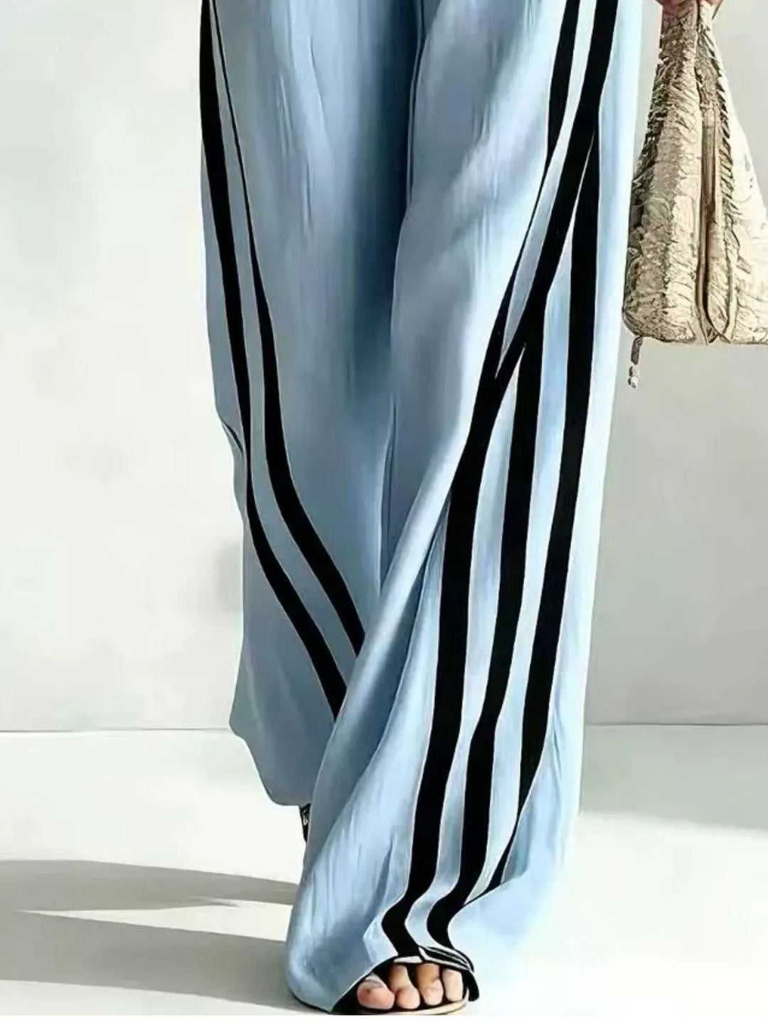Detail of the light blue wide leg pants with black side stripes