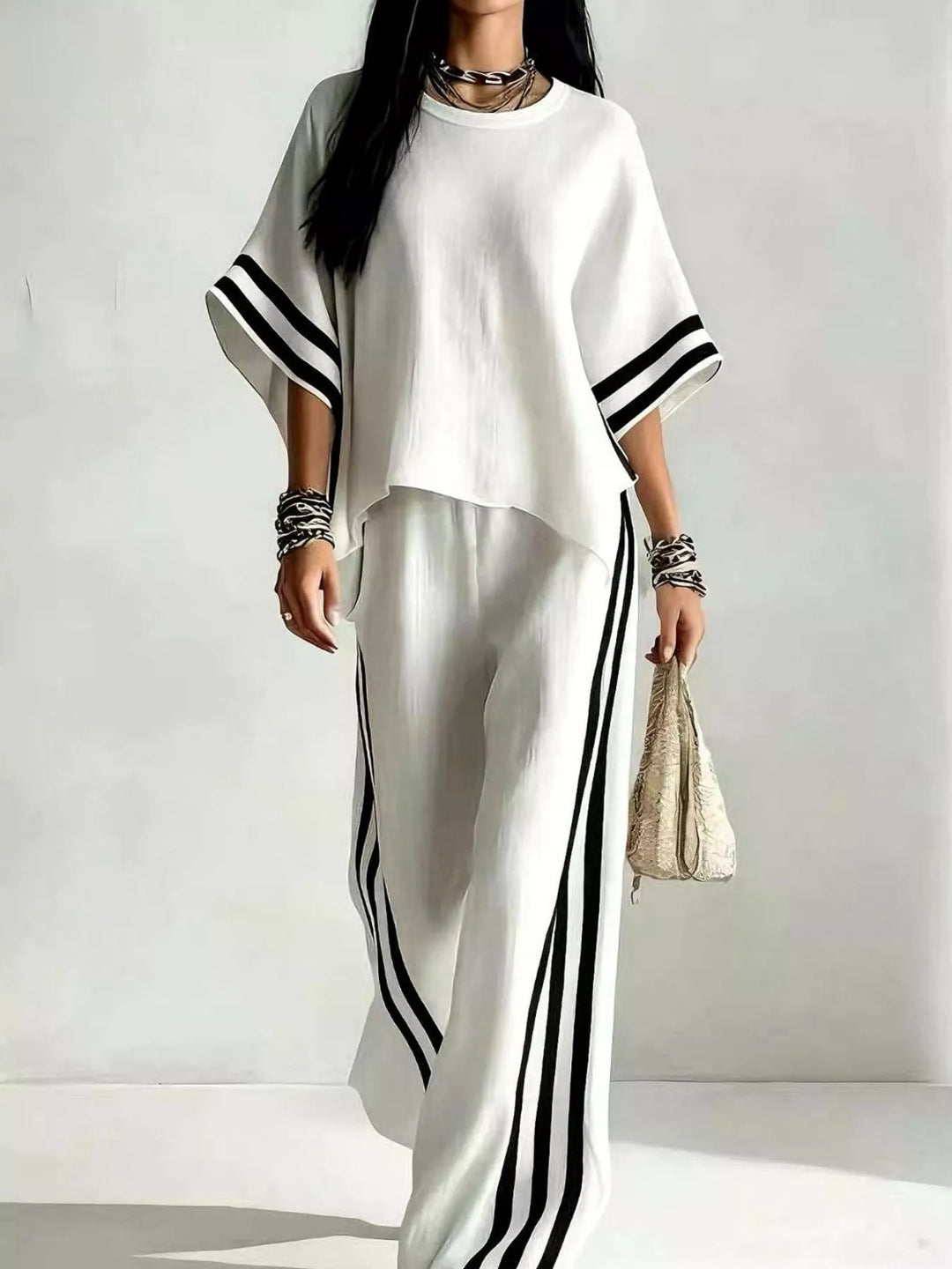 White matching set with wide sleeve top and black striped pants