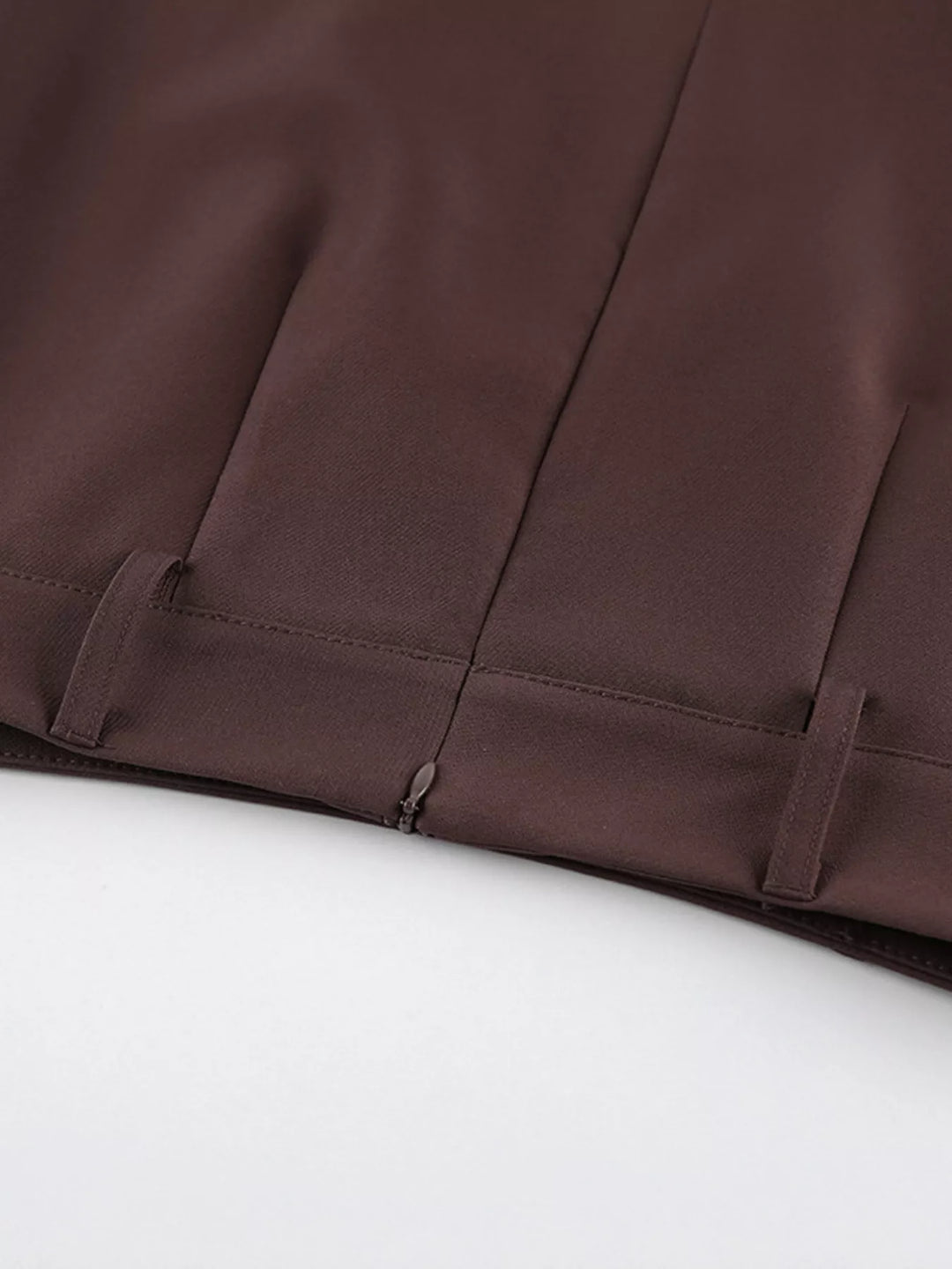 Close-up of the hidden zipper and pleat at the brown skirt waist