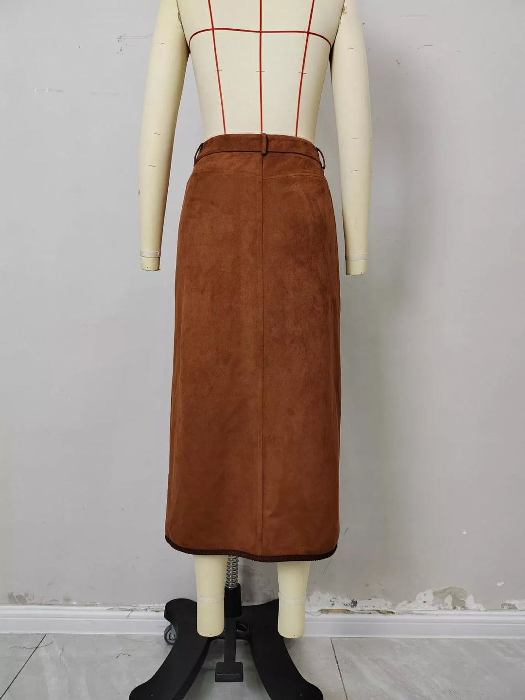Back view of the rust midi skirt on a mannequin with piped hem