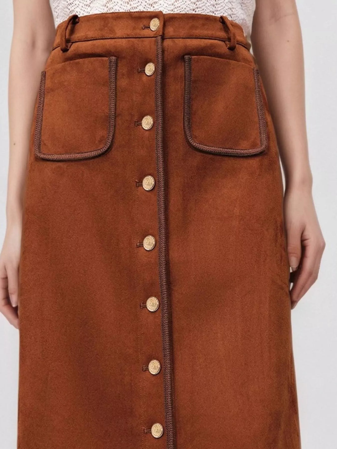 Close-up of the rust A line skirt button front and piped patch pockets