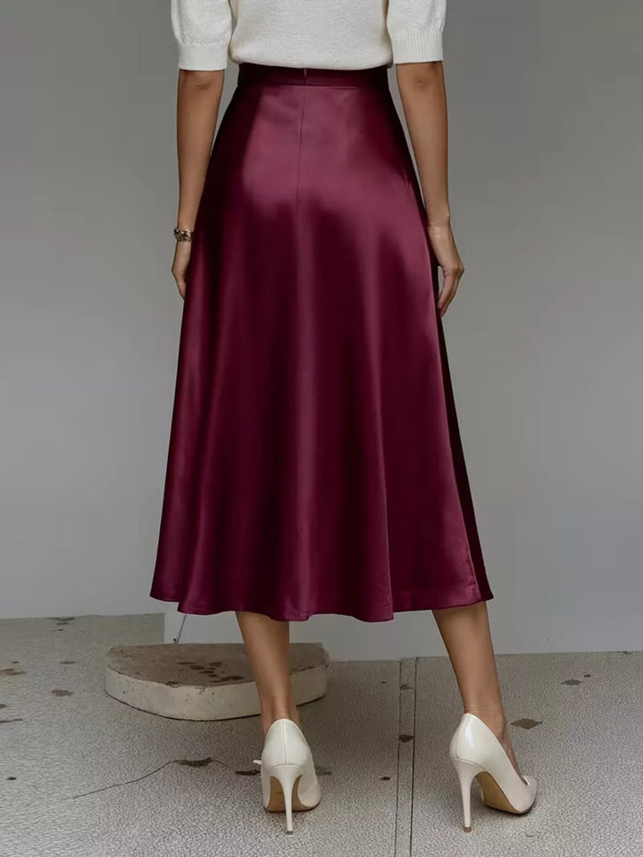 Back view of the burgundy satin look midi skirt with white pumps