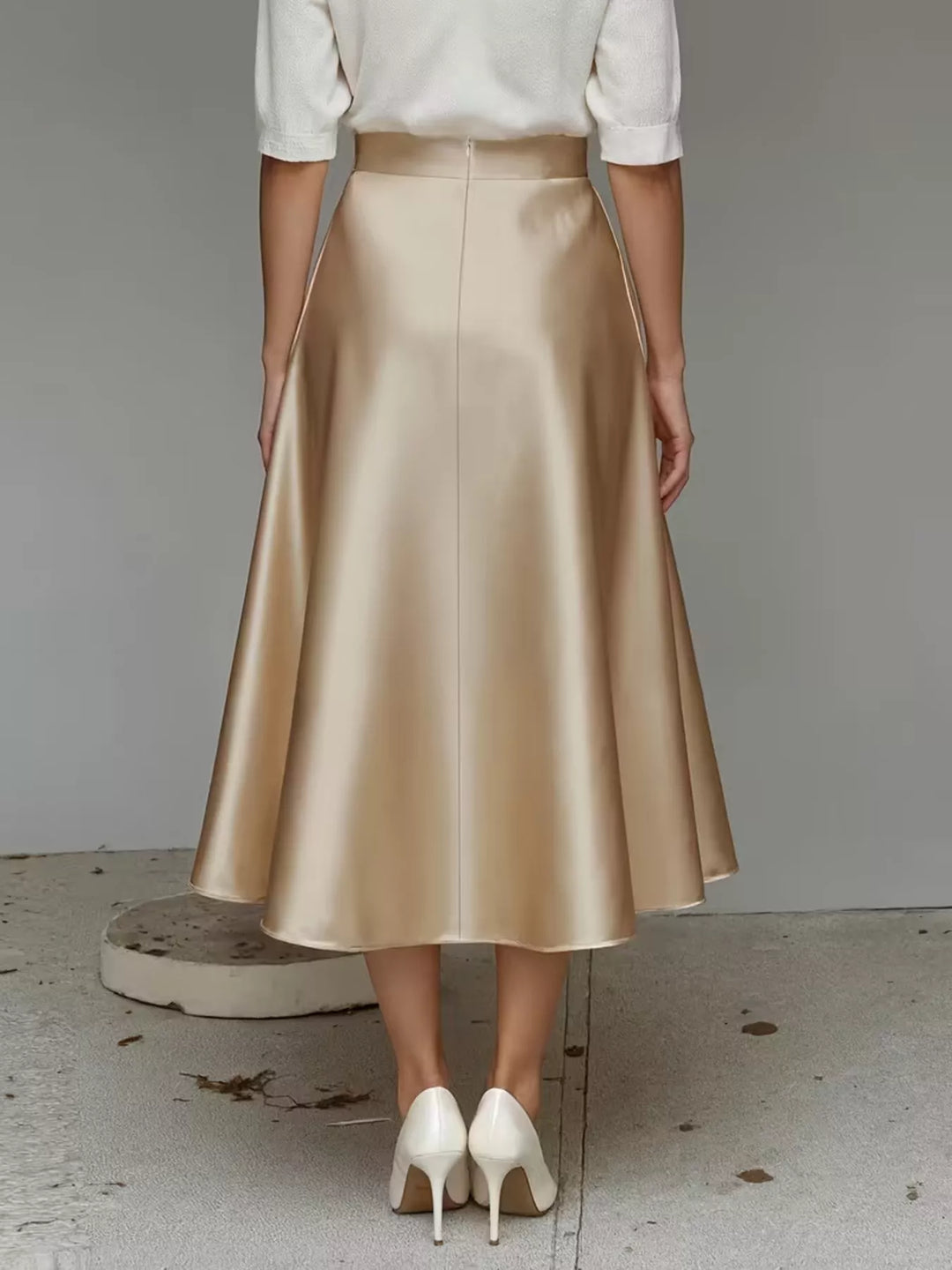 Rear view of the champagne satin look midi skirt with white pumps