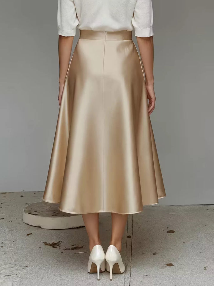 Rear view of the champagne satin look midi skirt with white pumps