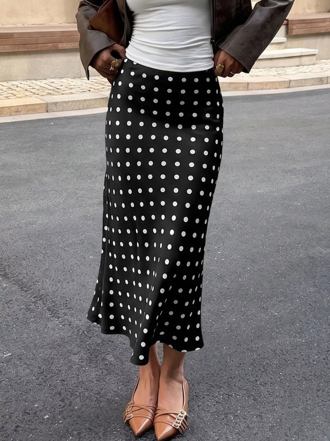 Black midi skirt with white polka dots and flared hem, front view