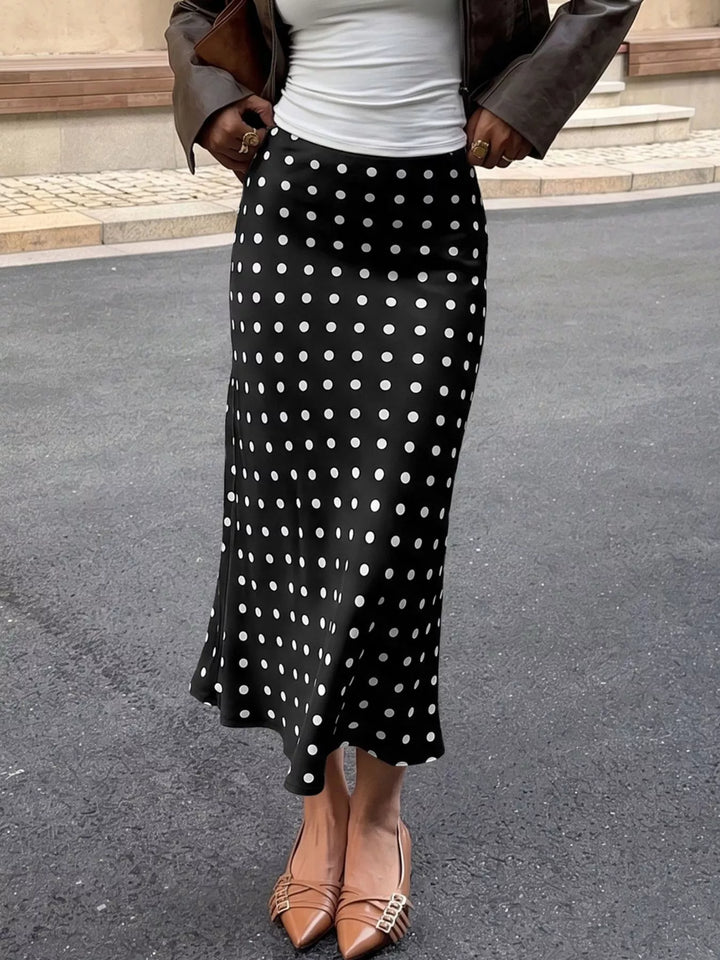 Black midi skirt with white polka dots and flared hem, front view