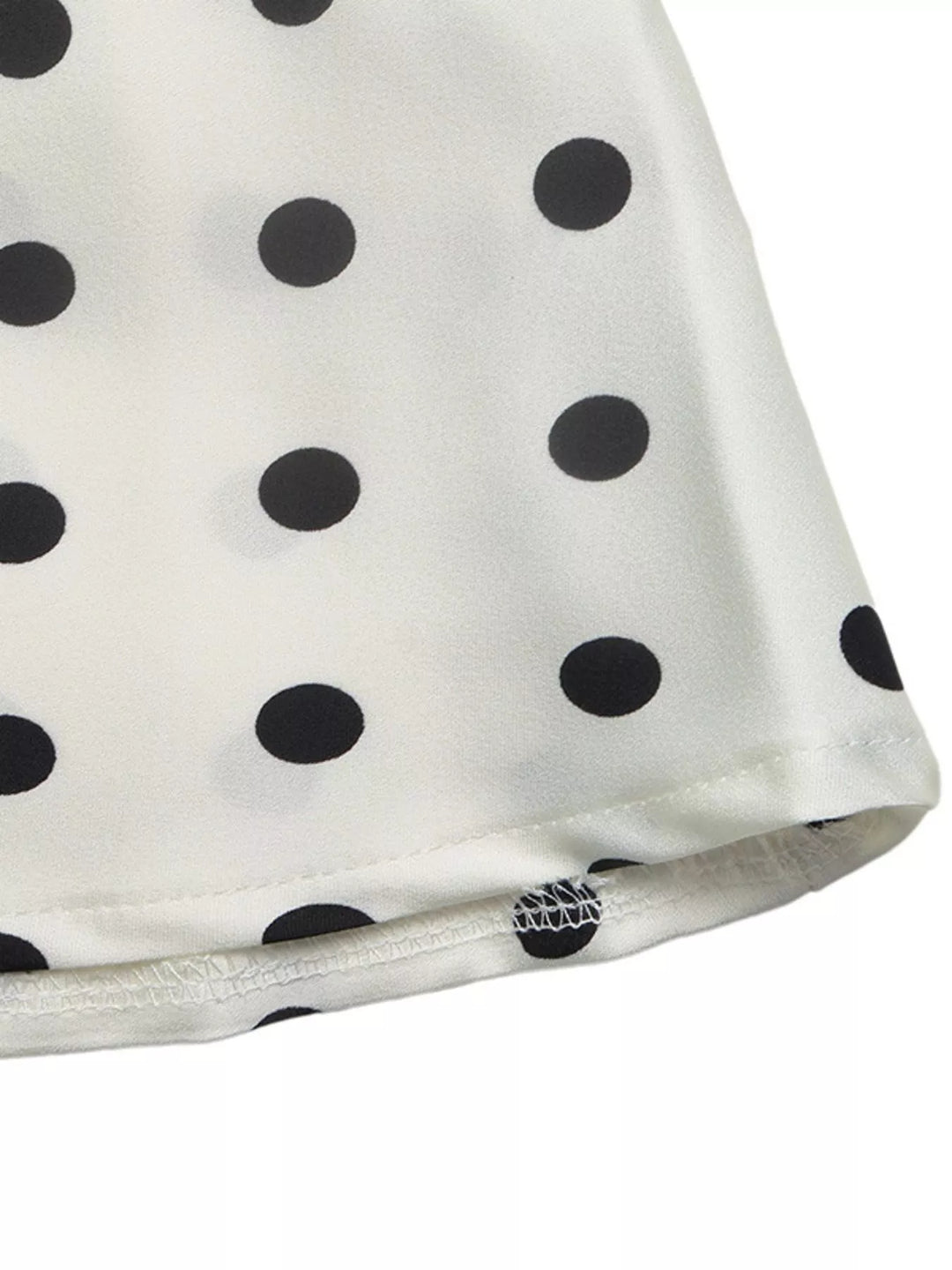 Close-up of the cream skirt hem with black polka dot print