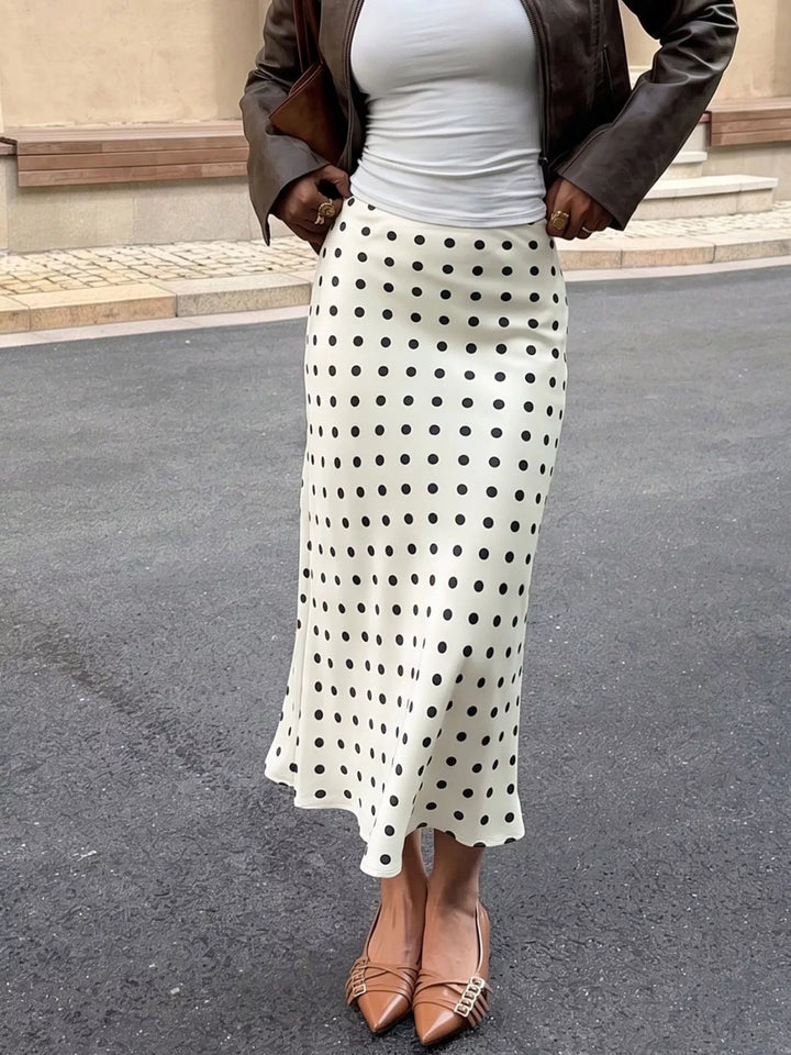 Cream polka dot midi skirt with leather jacket and coffee cup, outdoor front shot