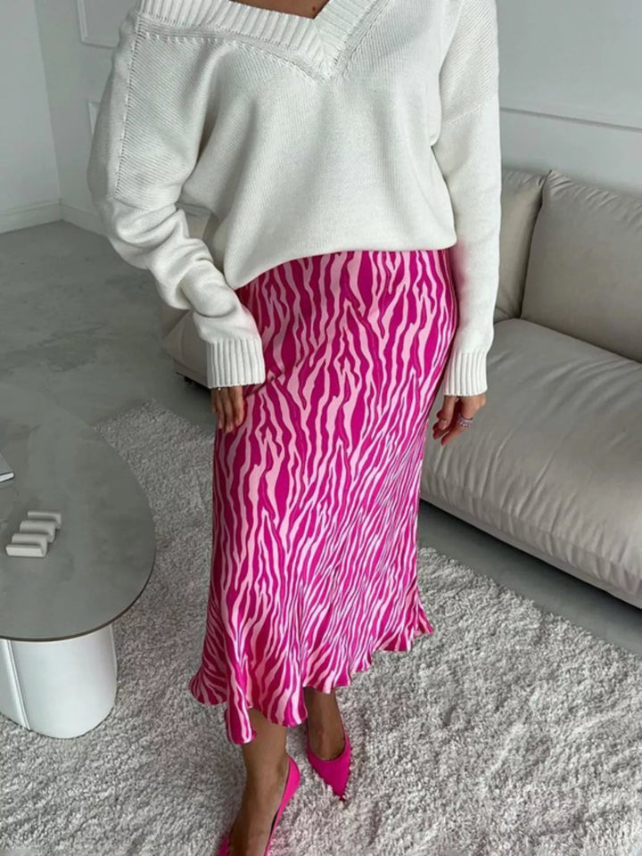 Front view of the hot pink flared hem midi skirt with a cream knit top