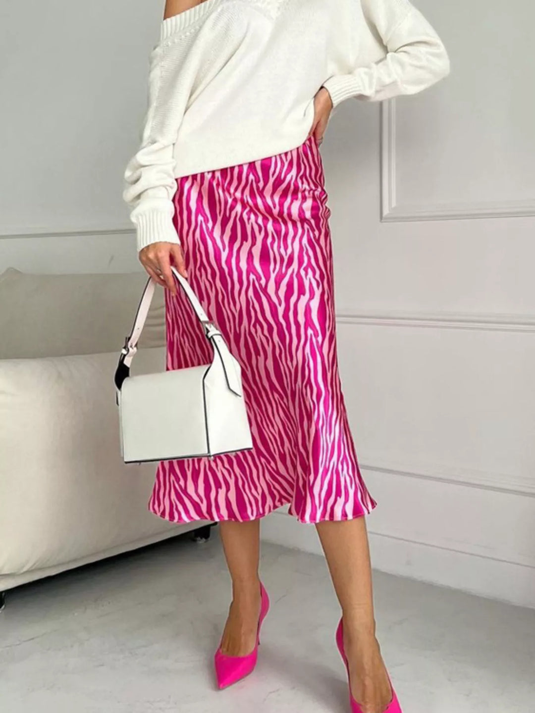 Hot pink zebra print midi skirt with white sweater, white handbag and pink heels