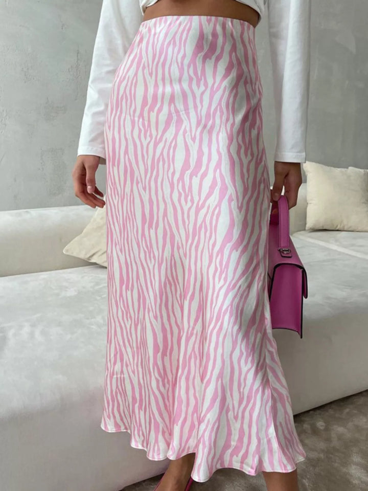 Light pink high waisted midi skirt from behind with a pink bag
