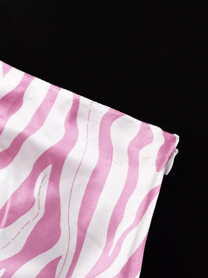 Detail of the light pink zebra print skirt side seam on a black background