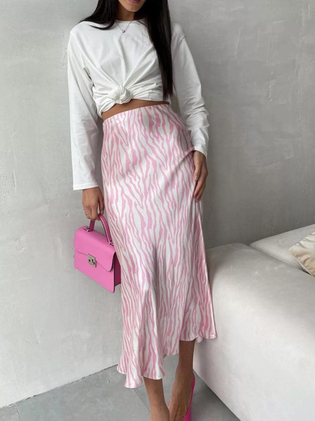 Light pink zebra midi skirt styled with a pink handbag, three quarter view
