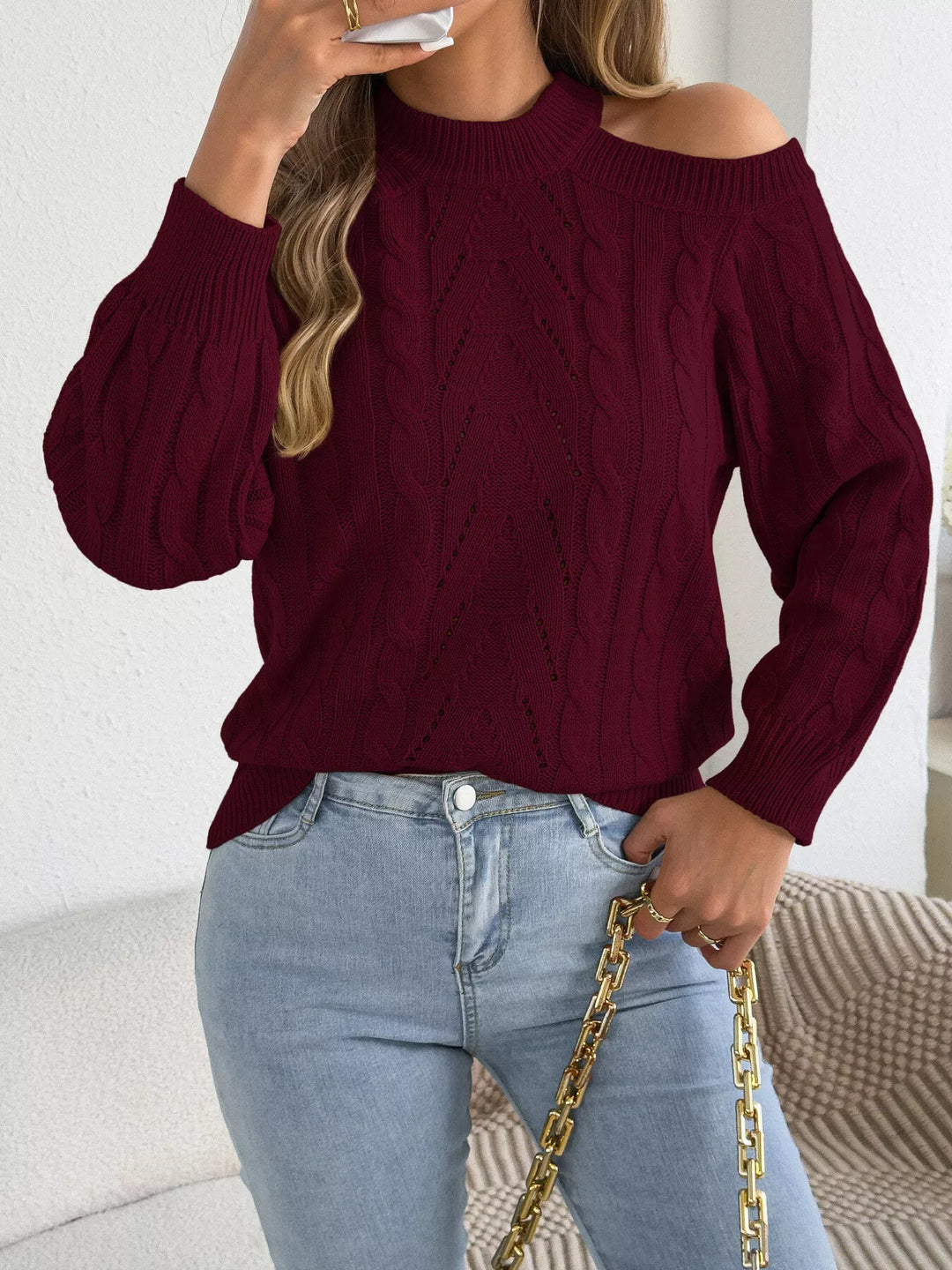 Burgundy cable knit sweater with a gold chain bag
