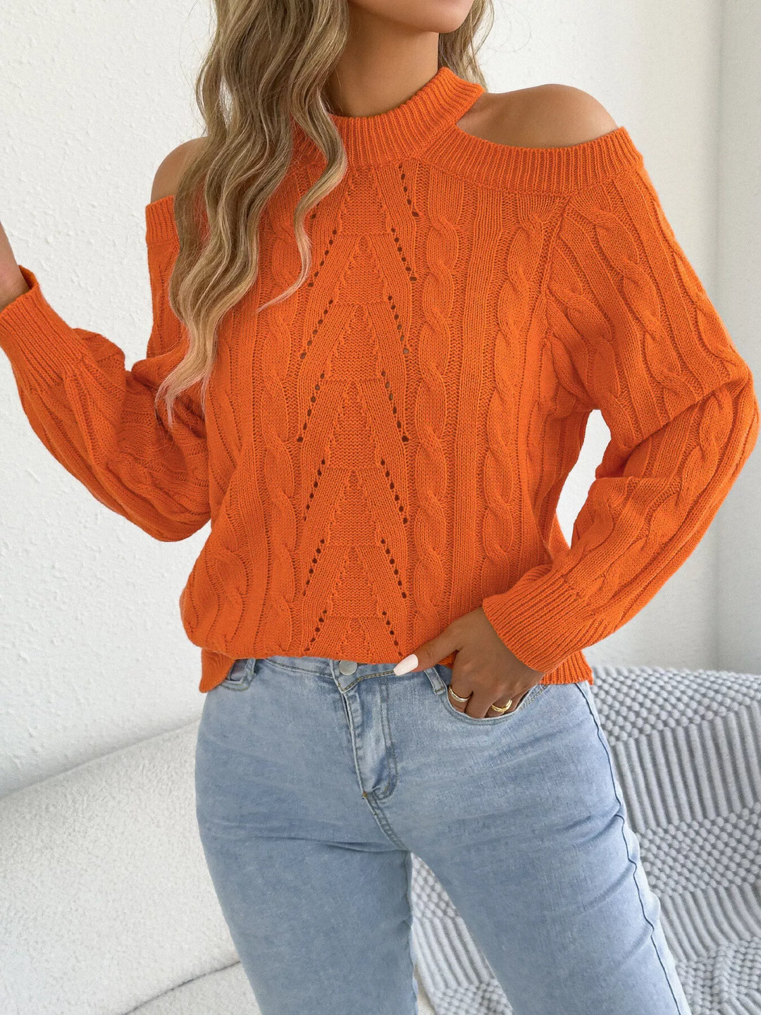 Orange cable knit sweater with cutouts styled with light wash jeans