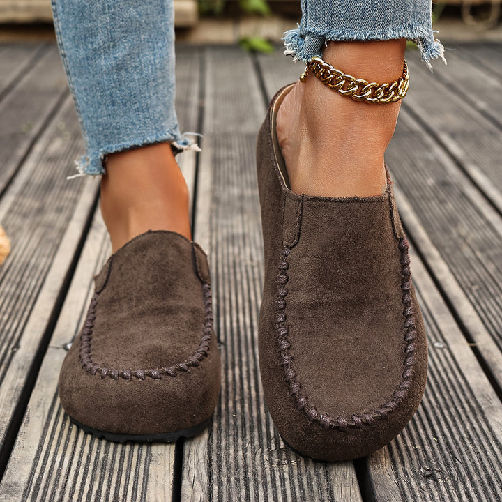 Brown backless slip on mules seen from the front