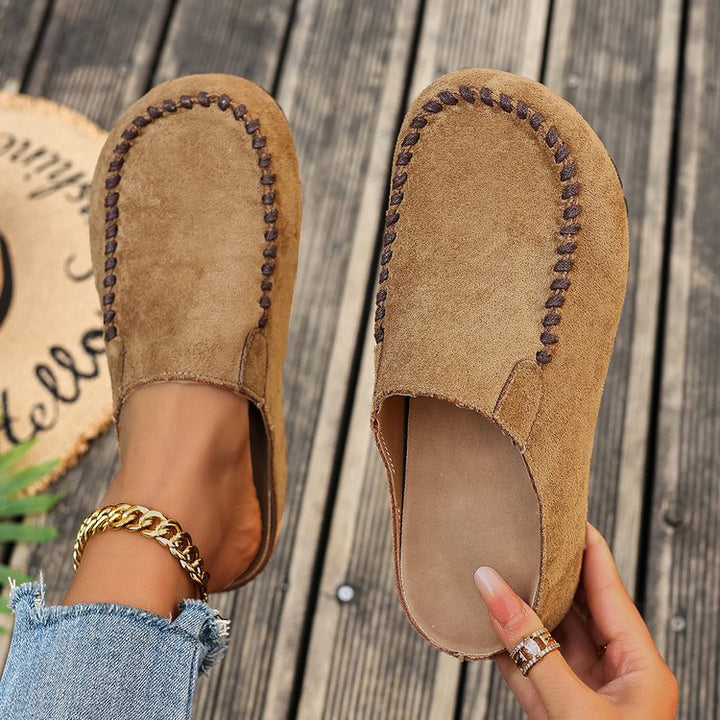Top view of tan backless mules showing the stitched toe and footbed