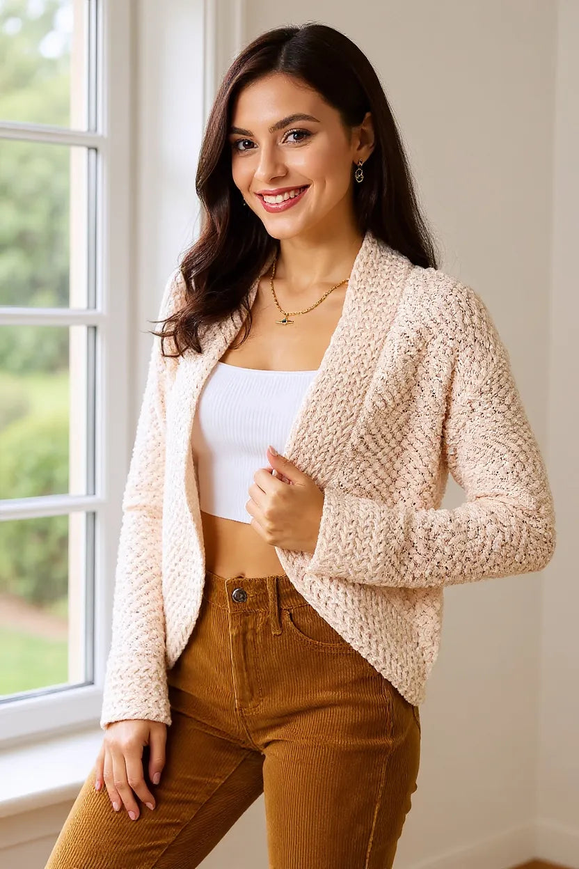 Women's open front cardigan in cream, cropped popcorn knit, smiling by a window