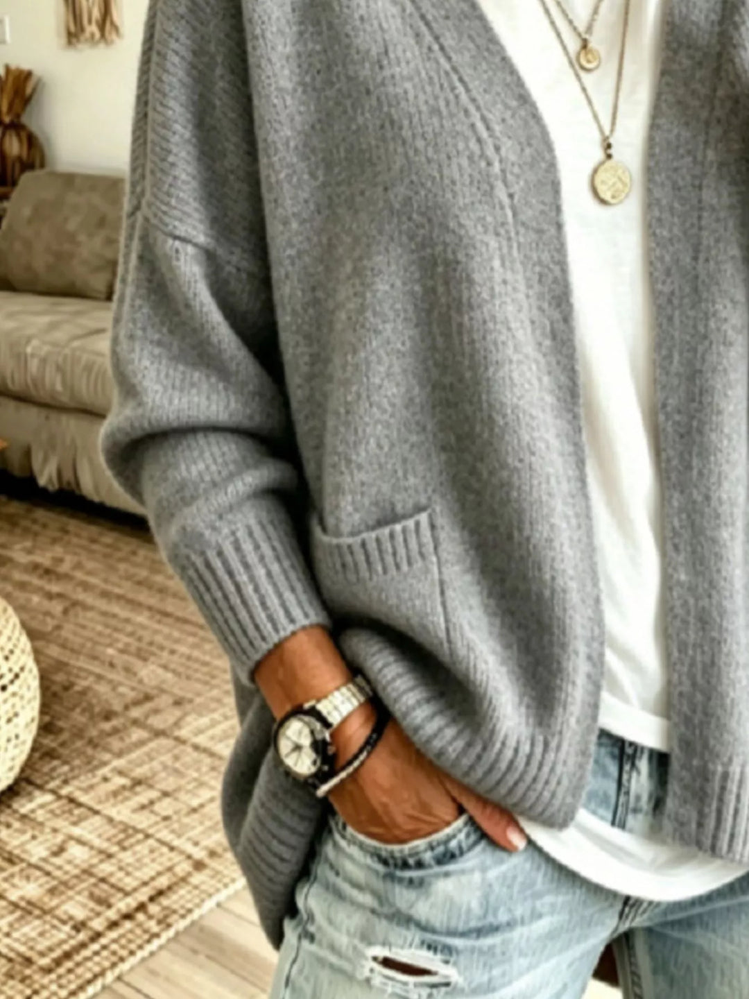 Close-up of the gray cardigan showing the ribbed cuff and patch pocket