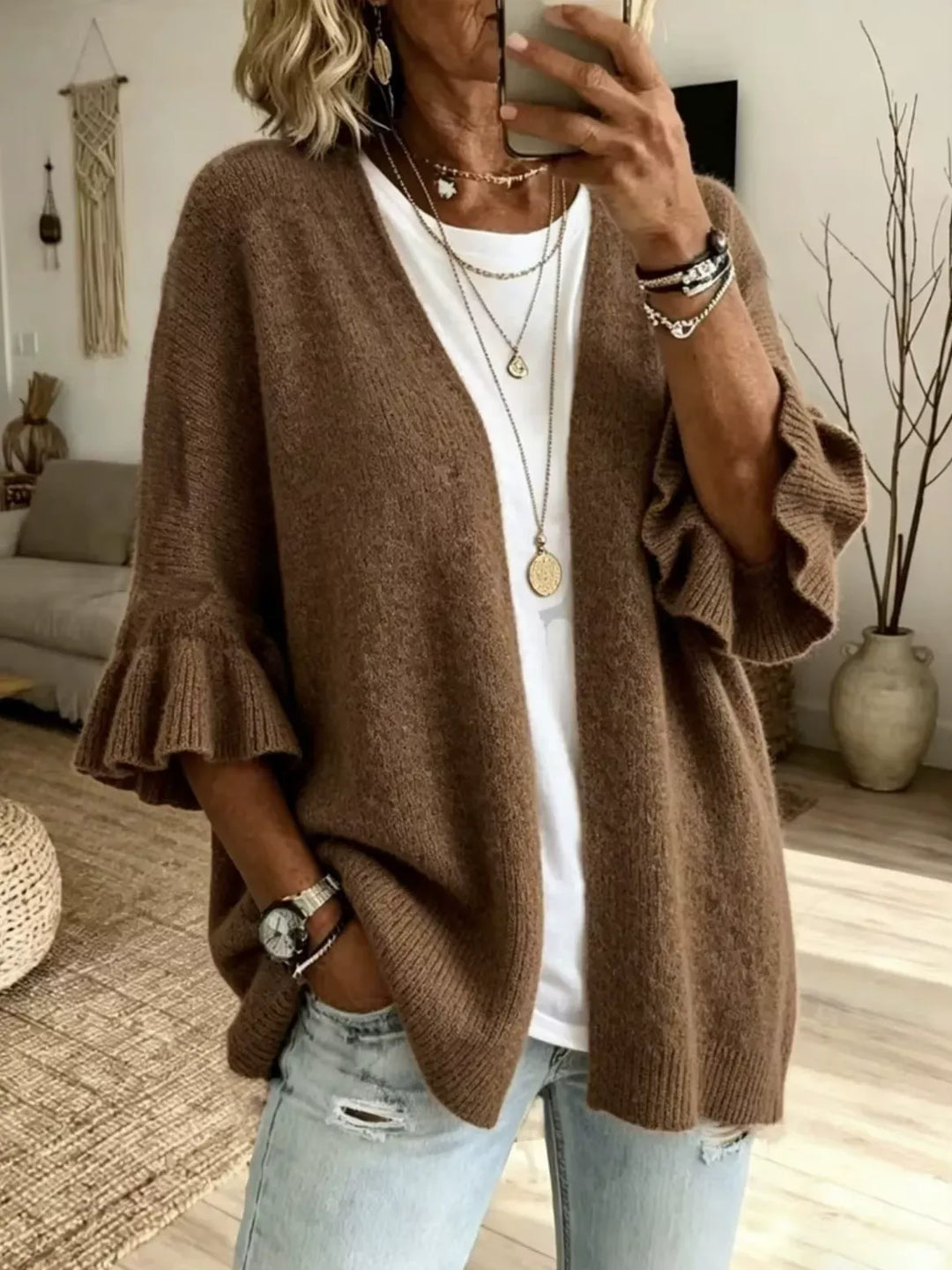 Women's open front cardigan in brown with ruffle cuffs, worn over a white tee and jeans