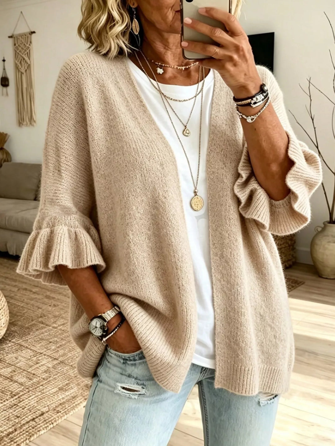 Oatmeal relaxed cardigan with ruffle cuffs worn over a white tee and jeans