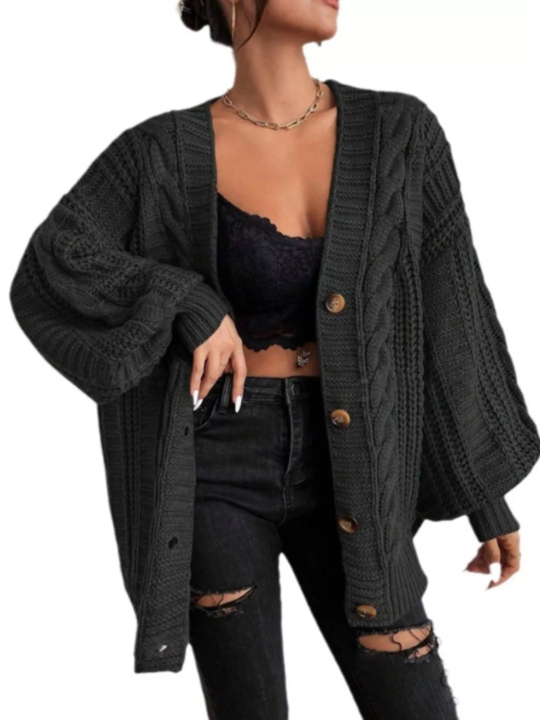 Black cable knit cardigan styled with a lace top and ripped black jeans