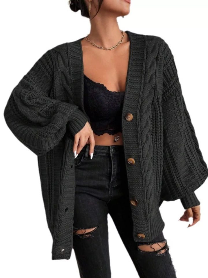 Black cable knit cardigan styled with a lace top and ripped black jeans