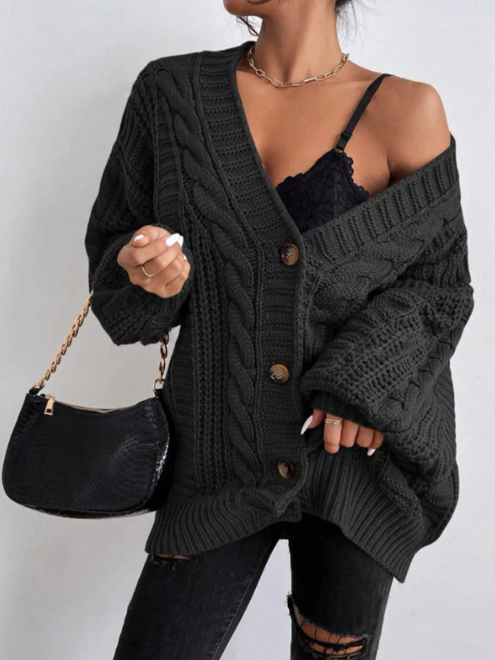 Black oversized cardigan slipped off one shoulder with a chain strap bag