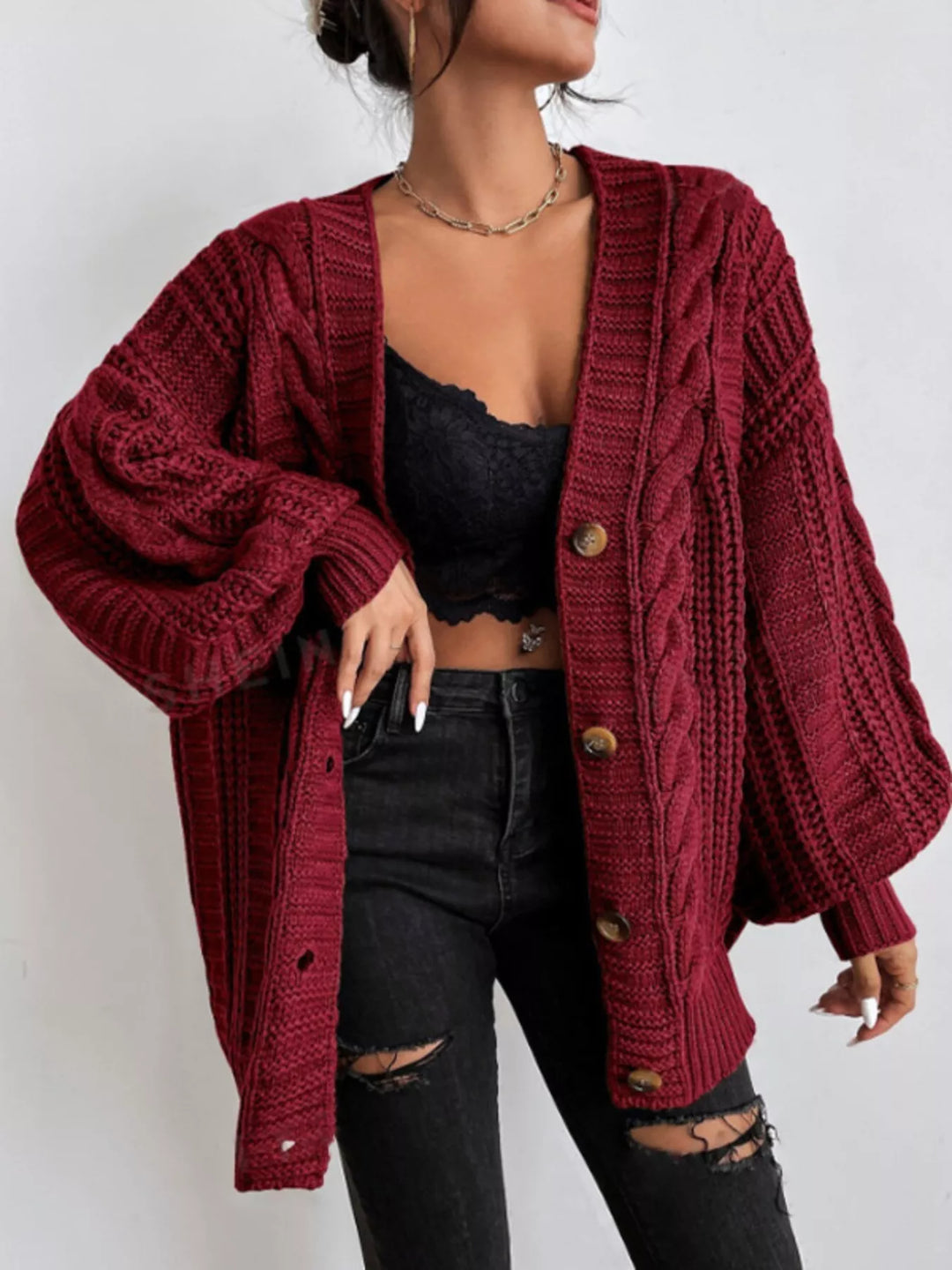 Burgundy oversized cable knit cardigan worn with black jeans
