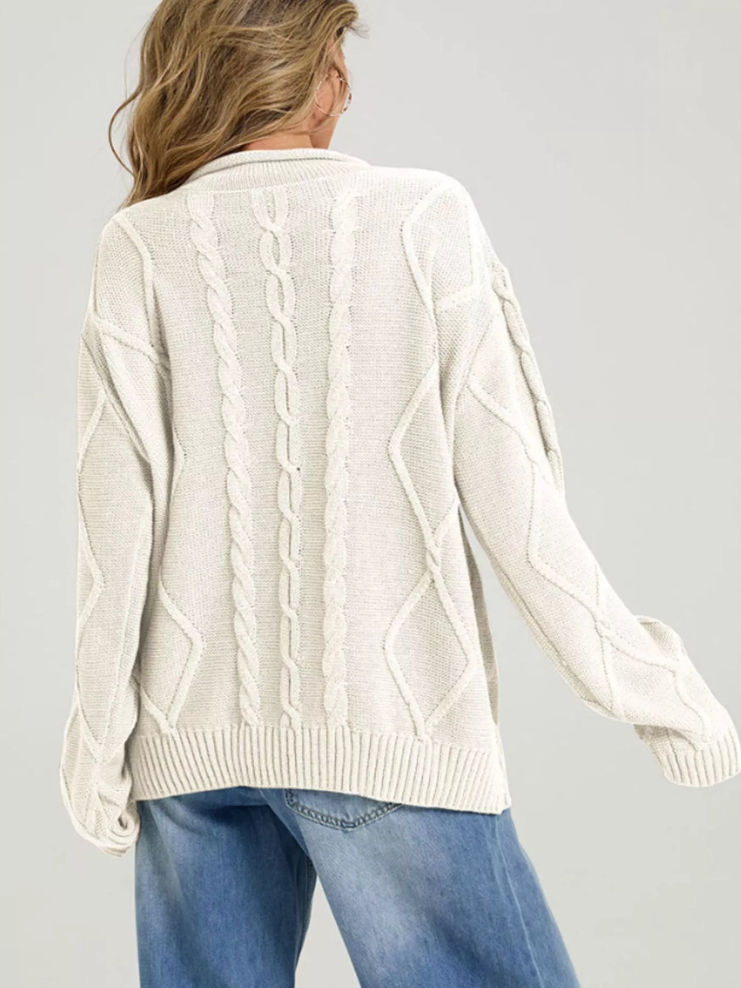 Back view of the cream cable knit sweater with relaxed fit