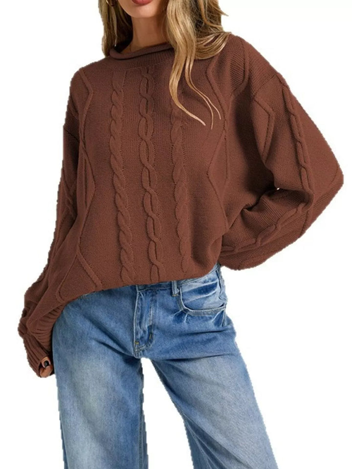 Rust brown oversized cable knit sweater, side pose with hand in jeans pocket