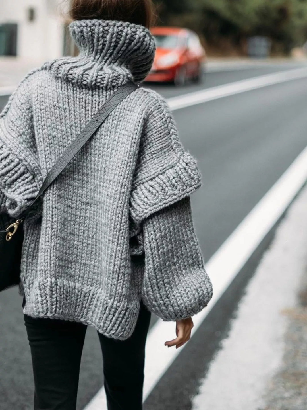 Gray chunky turtleneck sweater in a side view with a ribbed hem