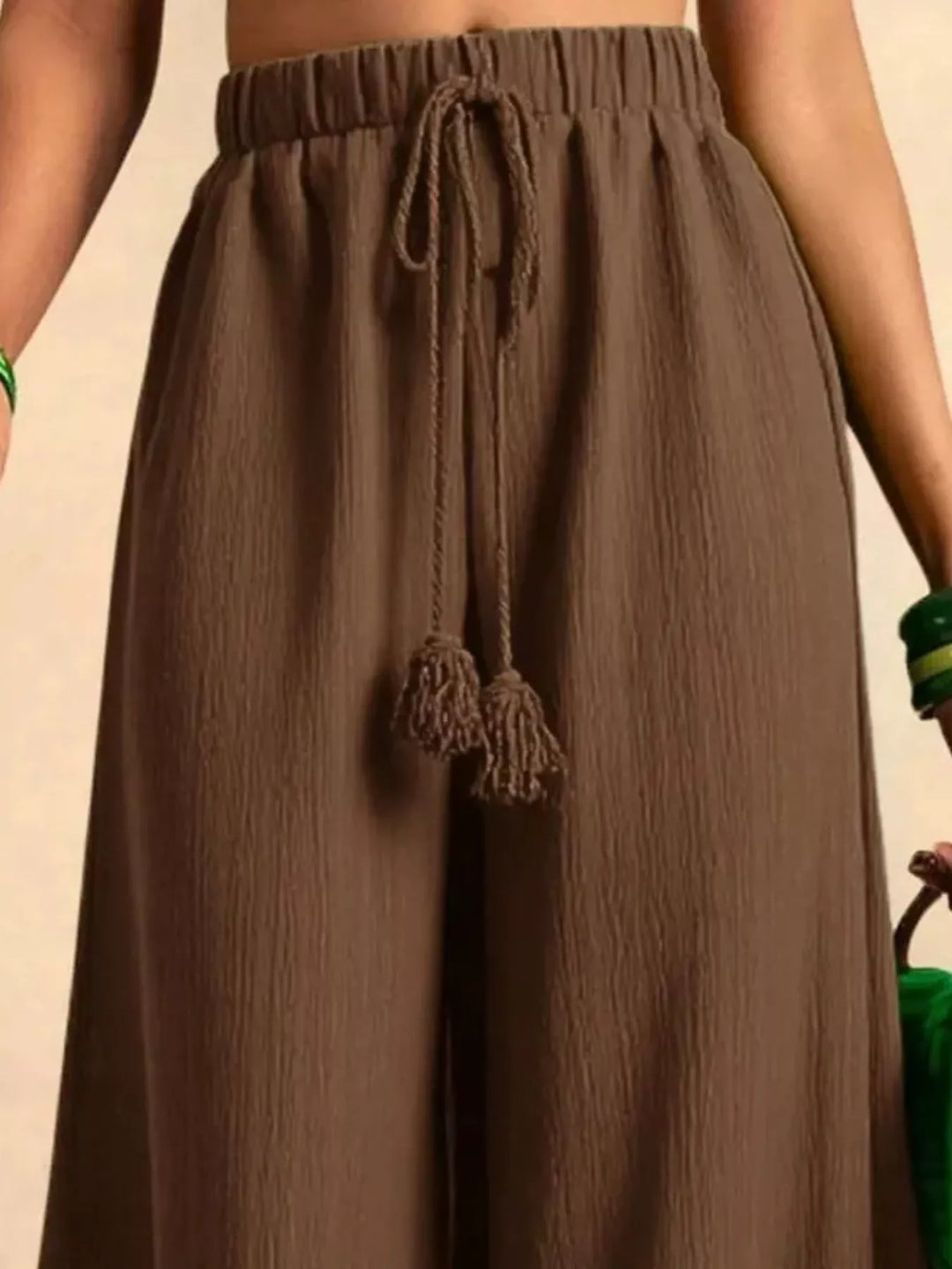 Close-up of the brown palazzo pants waist with the knotted tassel drawstring